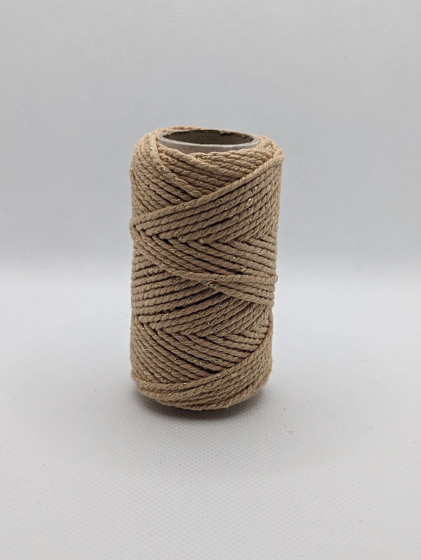 Image of a roll of 20m Bakers Twine. The colour is a beige with gold Shiny parts running through it. Great for wrapping packages and presents/ gifts.