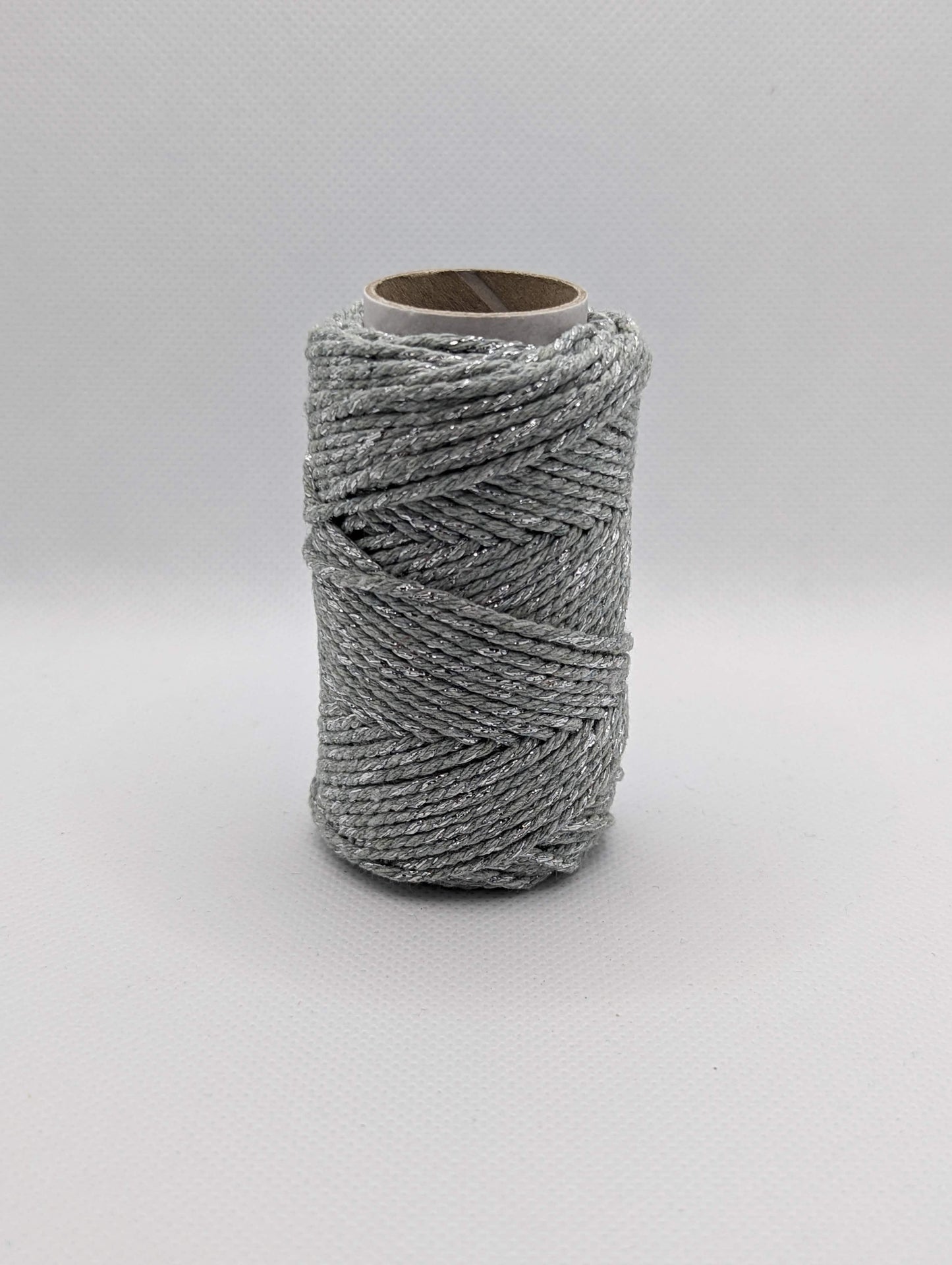 Image of a roll of 20m Bakers Twine. The colour is a grey with silver Shiny parts running through it. Great for wrapping packages and presents/ gifts.