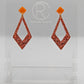 Shows a pair of 2 part earrings with stud fixings. The stud is on a small diamond shape with a larger kite shape dangling underneath. The colours are orange top and Copper Glitter Kite. They are on a clear stand against a white backing