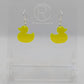 Shows a pair of acrylic earrings with silver ear wire hook fixings. They are rubber ducky / duck shapes. The colour of them is neon orange. They are on a see through stand that has the Ravenstor Creative Logo and its against a white background.