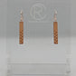 A pair or Natural Tan Leather earrings with rose gold fixings. They are thin and long and have a weave pattern that starts in the middle and goes down to the bottom. They against a white background on a clear stand with the Ravenstor Creative logo.