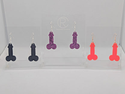 Image of three pairs of Earrings shaped like a Penis and Balls with ear wire hook fixings. These are ideal for funny Hen Dos or  Bachelorette parties. The colours are Black, Pink Glitter and Neon Pink. The are on Clear stands.