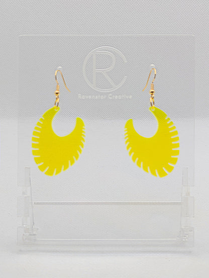 Image of a pair of acrylic earrings with Gold ear wire hook fixings. They are Ribbed half moon shapes with ridges around one side. They are Neon Orange and are on clear stands with the Ravenstor Creative logo on them against a white background.