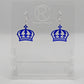 Shows a pair of acrylic earrings with silver ear wire hook fixings. They are Royal Crown shapes. The colour is Royal Blue Glitter. They are against a white background on clear stands with the Ravenstor Creative logo