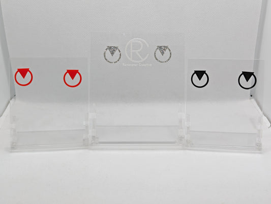 Shows three pairs of small studded acrylic earrings that are a circle hoop with a triangle inside it joining at the top. The colours are Red , Silver Glitter and Black. They are against a white background.