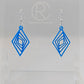 These are acrylic diamond shape earrings with twisted Geometric patterns cut into the middle. They have silver ear wire hook fixings and they are Blue in colour. They are on a clear stand against a white background.