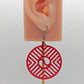 Image of a Circle earring with a Geometric Chevron design on an ear showing the size against a white background. It is translucent red acrylic and has black fixings.