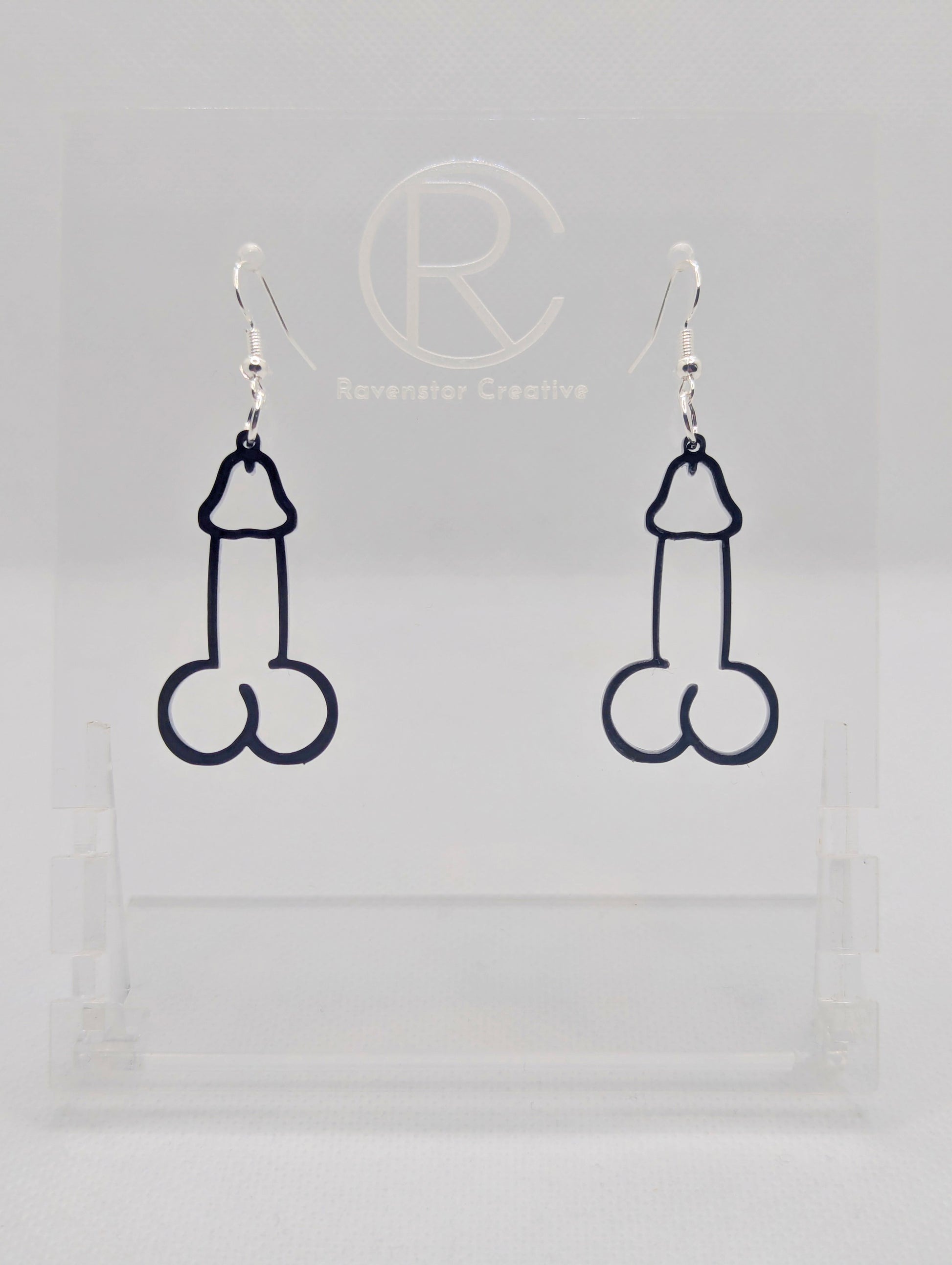 Image of a pair of earrings shaped like a Penis and Balls with Silver ear wire hook fixings. These are ideal for funny Hen Dos or Bachelorette parties. The colour is Black and they are on clear stands against a white background.