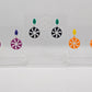 Three pairs of acrylic stud earrings. They are a small diamond shape with a spiral cut out of a circle dangling underneath. The colours are Purple and Pink Glitter. Green with Black and silver glitter. Yellow and orange.