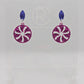 A pair of acrylic stud earrings. They are a small diamond shape with a spiral cut out of a circle dangling underneath. The colours are Purple and Pink Glitter. They are on a clear stand with the Ravenstor Creative Logo against a white background.