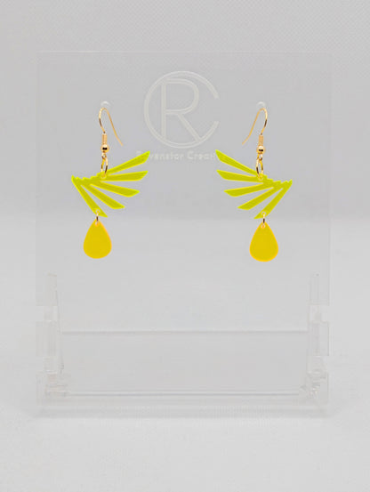 A pair of two part drop earrings with Gold ear wire hook fixings. Each one is a single wing with a teardrop balancing underneath it. The colours are Neon Yellow for the wing and neon orange for the teardrop. They are on clear stands.